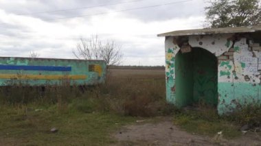 Ukrayna 'da savaş. 2022 Rus istilası Ukrayna. Altyapı tahribatı. Kırsal kesimde. Otobüs durağının bombalanmasından sonra hasar görmüş. Panorama. Kamera soldan sağa hareket ediyor.