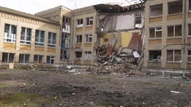 Ukrayna 'da savaş. 2022 Rus istilası Ukrayna. Altyapı tahribatı. Sivil halkın terörü. Savaş suçları. Okul bombardımandan zarar gördü. Panorama. Kamera soldan sağa hareket ediyor.
