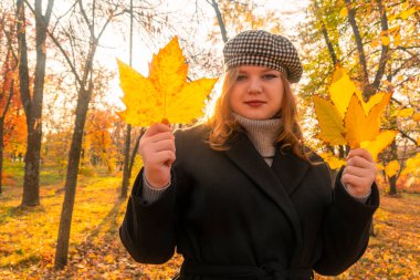 Sonbahar ormanı. Güneşli bir gün. Sarı yapraklar ağaçlardan düştü. Siyah paltolu bir kız elinde sarı yapraklar tutuyor. Ormanda sonbahar yürüyüşleri. Doğayla bağlantı