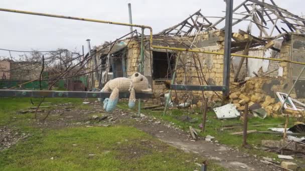ウクライナでの戦争 2022年 ロシアのウクライナ侵攻 田舎だ 貝によって破壊された家の背景におもちゃ テディベア パノラマ カメラは右から左に移動します — ストック動画