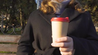 İyi akşamlar. Gün batımı. Şehir Parkı. İş gününün sonunda. Elde bir fincan kahve (yakın çekim, panorama, kamera soldan sağa hareket eder). Açık hava yürüyüşleri