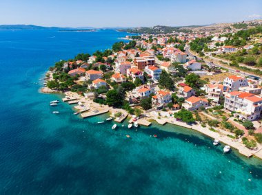 Hırvatistan. Yaz. Güneşli bir gün. Adriyatik Denizi kıyısında. Deniz kenarında küçük bir kasaba. Tatil sezonu. Popüler turist mekanı. Drone. Hava görünümü