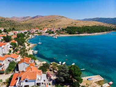 Hırvatistan. Yaz. Güneşli bir gün. Adriyatik Denizi kıyısında. Deniz kenarında küçük bir kasaba. Tatil sezonu. Popüler turist mekanı. Drone. Hava görünümü