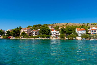 Hırvatistan. Yaz. Güneşli bir gün. Adriyatik Denizi kıyısında. Deniz kenarında küçük bir kasaba. Tatil sezonu. Popüler turizm merkezi