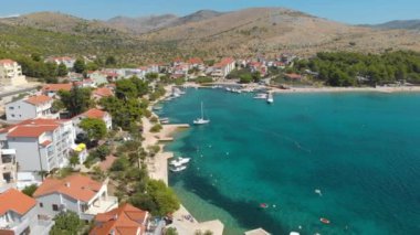 Croatia. Coast of the Adriatic Sea. Small town by the sea. Summer. Tourist season. Popular place to relaxation. Drone. Aerial view. The camera moves forward