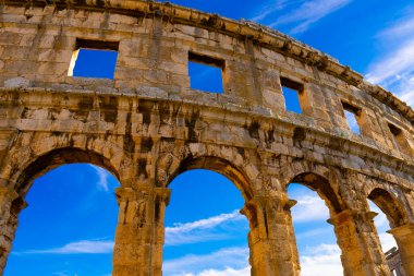 Güneşli bir hava. Mavi gökyüzüne karşı antik Roma amfitiyatrosunun duvarları. Tarihi öneme sahip antik Roma mimarisinin bir anıtı.