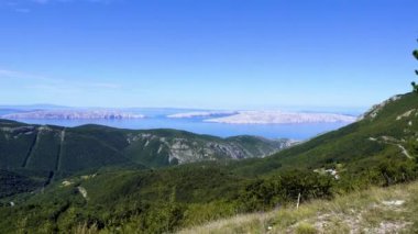 Hırvatistan. Dağ manzarası. Yaz. Güneşli bir gün. Kamera sağdan sola hareket ediyor.