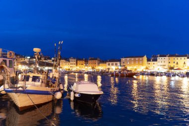 Hırvatistan. Rovinj şehri. Popüler turist mekanı. Yaz akşamı. Balıkçı tekneleri ve turist tekneleriyle şehir iskelesi