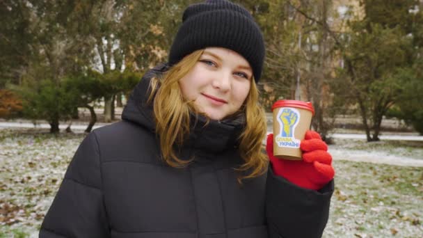 Zimą Dziewczyna Trzyma Ręku Filiżankę Kawy Naklejką Patriotyczną Robi Znak — Wideo stockowe