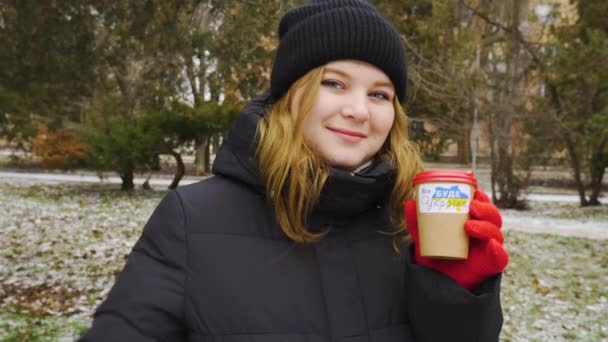 Zimą Dziewczyna Trzyma Ręku Filiżankę Kawy Naklejką Patriotyczną Robi Znak — Wideo stockowe
