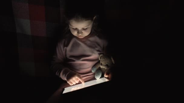Mała Dziewczynka Zabawką Pluszowy Miś Używa Tabletu Ciemnym Pomieszczeniu Aparat — Wideo stockowe