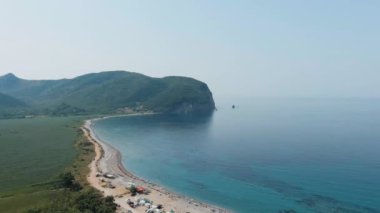 Karadağ. Adriyatik Denizi kıyısında. Plajda otomobil kampı. Yaz. Turizm sezonu. Denizde dinlen. Drone. Hava görüntüsü. Kamera ileri gidiyor.