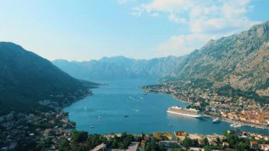 Karadağ. Drone. Kotor Körfezi üzerinde uçuş. Kamera ileri gidiyor. Adriyatik Denizi 'ndeki en büyük körfez. Avrupa 'nın en güneyindeki fiyort. Otoparkta bir yolcu gemisi var.