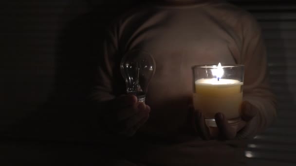 Girl Dark Room Holds Candle Electric Light Bulb Her Hands — Vídeos de Stock