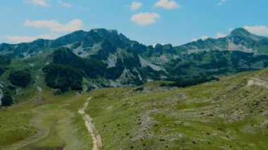 Karadağ. Durmitor Ulusal Parkı. Eyer Geçidi. Alp çayırları. Dağ manzarası. Drone. Hava görüntüsü. Kamera ileri gidiyor.