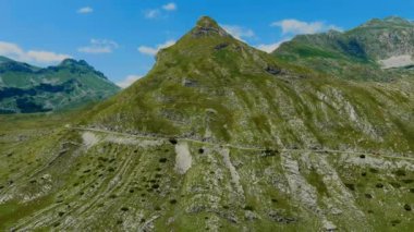 Karadağ. Durmitor Ulusal Parkı. Eyer Geçidi. Alp çayırları. Dağ manzarası. Drone. Hava görüntüsü. Kamera ileri gidiyor.