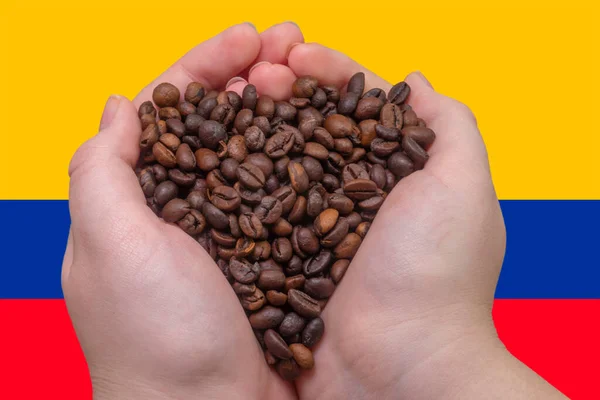 A handful of coffee beans close-up against the background of the flag of Colombia (close-up). The largest exporter of coffee in the world. Colombian coffee