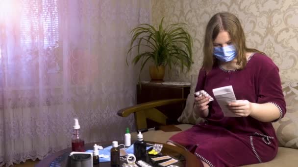 Egy Megfázás Tüneteit Mutató Lány Kanapén Elolvassa Gyógyszer Használati Utasítását — Stock videók
