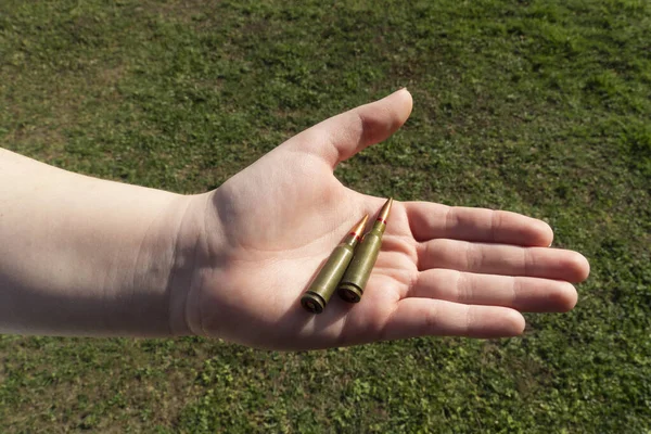 Tüfek Fişeği Elinde Yeşil Çimlerin Arka Planına Karşı Yakın Plan — Stok fotoğraf