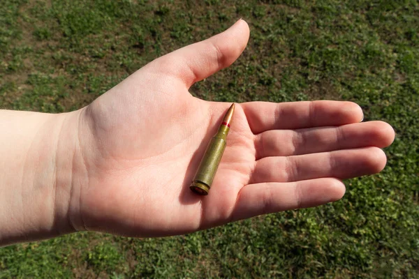 Rifle Cartridge Hand Een Achtergrond Van Groen Gras Close — Stockfoto