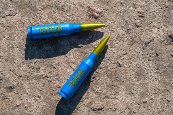 Two Yellow Blue Rifle Cartridges Inscription Stop War Lie Concrete — Stock Photo, Image