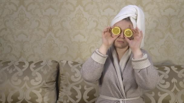 Una Ragazza Accappatoio Siede Divano Chiude Gli Occhi Con Limoni — Video Stock
