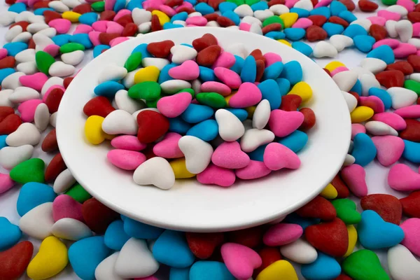 Fehér Tányér Többszínű Szív Alakú Cukorkákkal Közelkép Ugyanazon Sokszínű Cukorkák — Stock Fotó