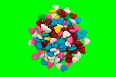 Yeşil arka planda (kroma anahtarı) bir demet çok renkli kalp şeklinde şeker (yakın plan). Yukarıdan görüntüle
