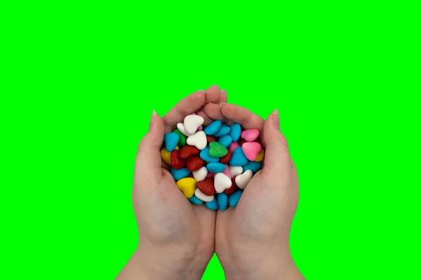 Garstka Wielobarwnych Cukierków Kształcie Serca Dłoniach Zielonym Tle Klucz Chroma — Zdjęcie stockowe