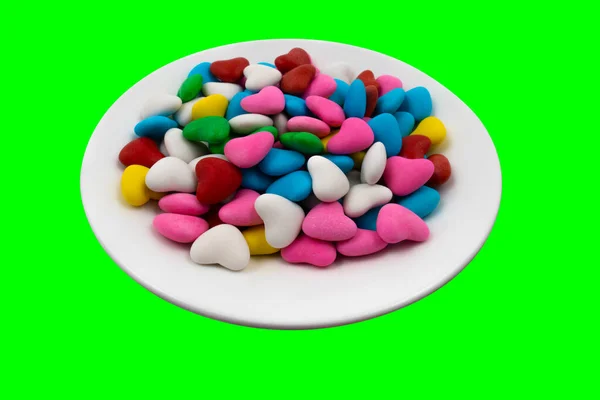 Ένα Λευκό Πιάτο Πολύχρωμες Καραμέλες Σχήμα Καρδιάς Close Πράσινο Φόντο — Φωτογραφία Αρχείου