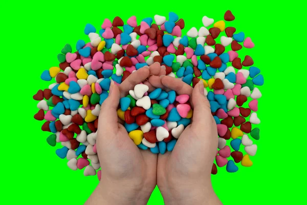 Garstka Wielobarwnych Cukierków Kształcie Serca Dłoniach Zielonym Tle Klucz Chroma — Zdjęcie stockowe