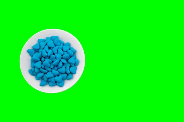 Белая Тарелка Голубыми Конфетками Форме Сердца Крупным Планом Зеленом Фоне — стоковое фото