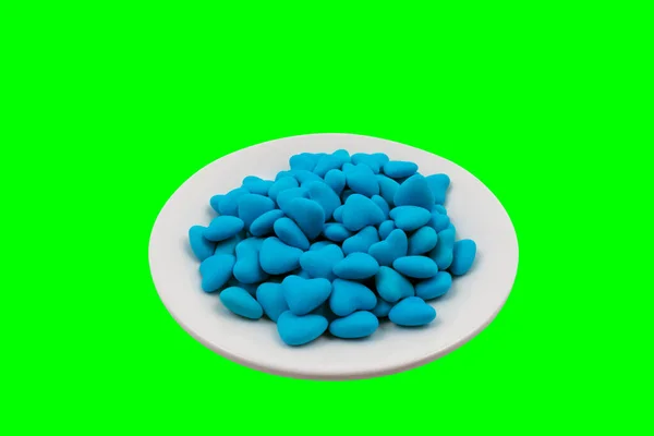 White Plate Blue Heart Shaped Candies Close Green Background Chroma — Stock Photo, Image