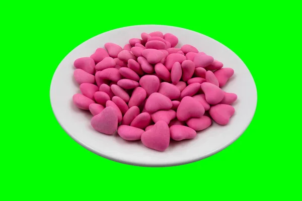 Λευκό Πιάτο Ροζ Καραμέλες Σχήμα Καρδιάς Close Πράσινο Φόντο Chroma — Φωτογραφία Αρχείου