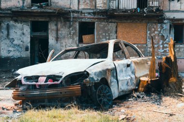 Roket atışıyla yıkılan bir binanın yanında yanmış bir araba. Ukrayna 'da savaş. Sivil halkın terörü