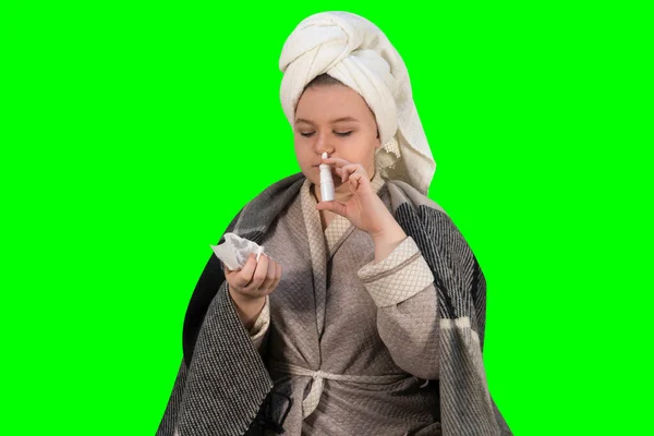 緑の背景 クロマケイ に風邪の症状を持つ少女は 彼女の鼻にスプレーを注入します 鼻水とアレルギーです 在宅治療の概念 — ストック写真