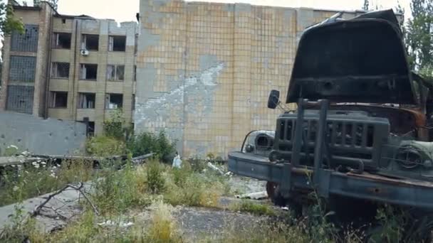 破壊された軍用トラックが街の通りに立っています パノラマ カメラは左から右にパンします ウクライナでの戦争 ロシアによるウクライナ侵攻 — ストック動画