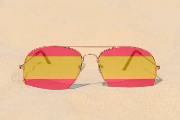 Piasku Leżą Okulary Przeciwsłoneczne Okularami Kształcie Flagi Hiszpanii Koncepcja Wakacji — Zdjęcie stockowe