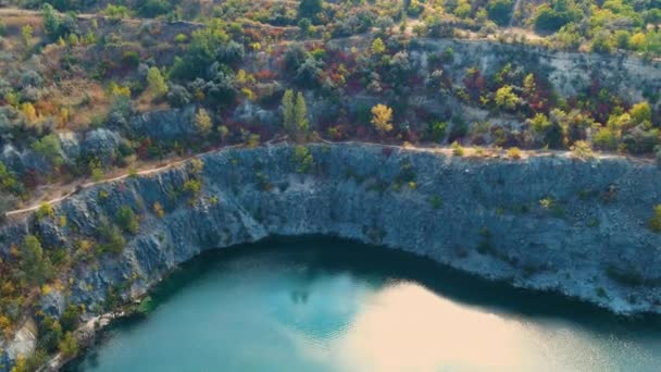明確なターコイズ水で浸水し放棄された花崗岩の採石場のトップビュー 晴れた秋の日 ドローン カメラは左から右に円で移動します — ストック動画
