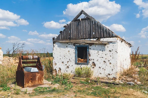 Kırsal kesimde. Evin önündeki avluda bir su kuyusu, bombardımanla yıkıldı. Ukrayna 'da savaş. Rus işgali Ukrayna 'da. Sivillerin dehşeti. Savaş Suçları