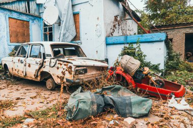 Kırsal kesimde. Evin avlusunda bir araba, topçu bombardımanından zarar görmüş. Ukrayna 'da savaş. Rus işgali Ukrayna 'da. Sivillerin dehşeti. Savaş Suçları