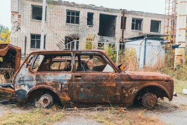 Yolun kenarında hurdaya dönmüş, yanmış bir sivil araba var. Ukrayna 'da savaş. Rus işgali Ukrayna 'da. Savaş Suçları