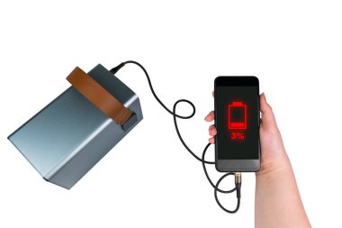 Öte yandan bir akıllı telefon ve bir USB kablosu beyaz arka plandaki bir güç bankasına (şarj istasyonu) bağlıdır. Akıllı telefon ekranında - yeşil pil göstergesi% 100 (tam şarj)