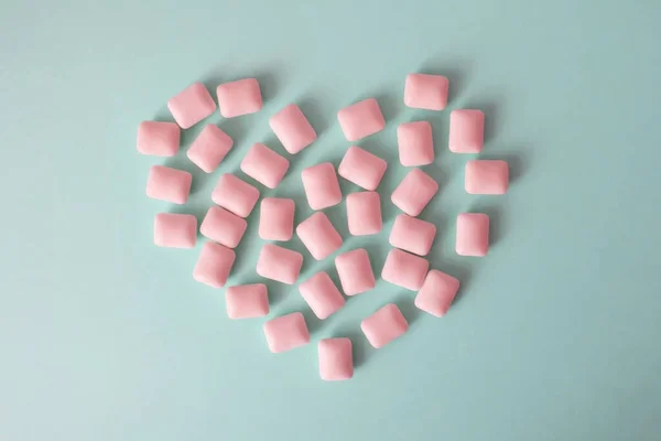 Roze Kauwgom Vorm Van Een Hart Een Blauwe Achtergrond — Stockfoto
