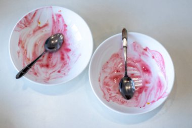 Beyaz arka planda beyaz kirli plakalar. Tabaktaki böğürtlenlerden pembe lekeler. Yukarıdan görüntüle