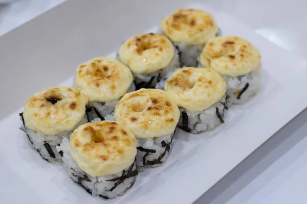 Japanese baked rolls. Rolls with nori, fish and cream cheese on top. Asian cuisine, home delivery of rolls