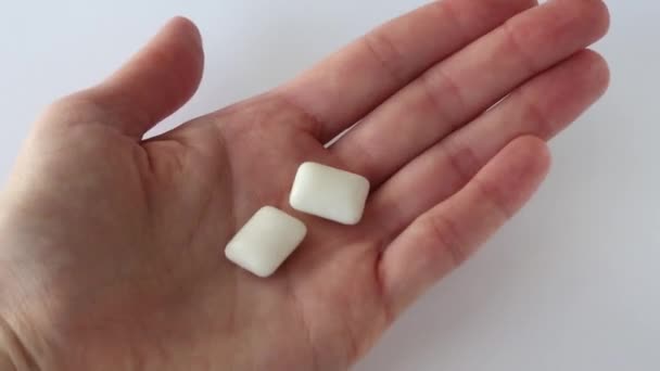 Due Gomme Gommose Nelle Mani Delle Donne Uno Sfondo Bianco — Video Stock