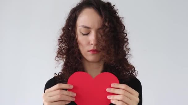 卷曲头发的女人把她的纸心撕碎了 一个心烦意乱的女孩经历了一次分手 失恋的概念 — 图库视频影像