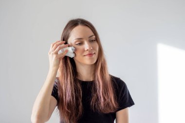 Mutlu kadın yüz mikro akımı yapıyor. Evde akımlı bir cihazla yüz masajı.