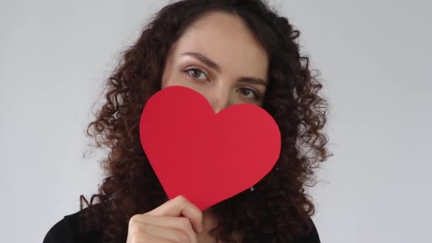 Приваблива Молода Жінка Тримає Червоне Паперове Серце Кінці Вказуючи Його — стокове відео